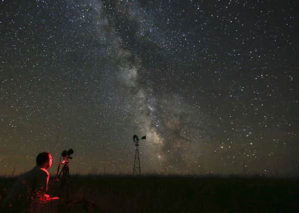 Lane Hickenbottom photographs the night sky near Callaway, Nebraska. Picture: Travis Heying/The Wichita Eagle via AP