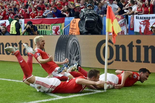 Wales midfielder Aaron Ramsey, kneeling, and defender Chris Gunter celebrate the winning goal by Hal Robson-Kanu, right. Picture:  Georges Gobet/AFP/Getty