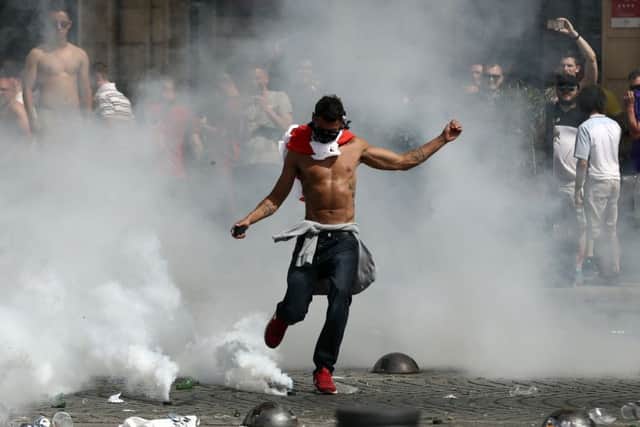 An England supporter kicks away a teargas canister fired by French police during trouble before the match with Russia in Marseille. Picture: Getty Images