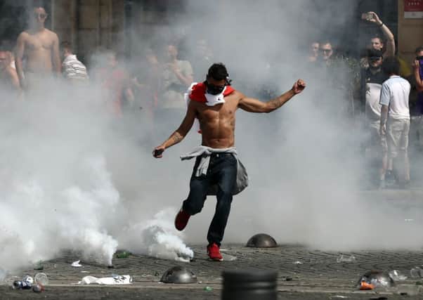 An England supporter kicks away a teargas canister fired by French police during trouble before the match with Russia in Marseille. Picture: Getty Images