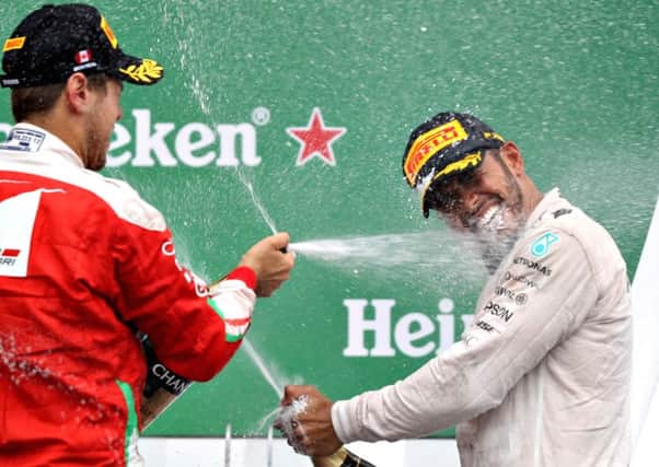 Canadian Grand Prix winner Lewis Hamilton is sprayed with champagne by Sebastian Vettel. Picture: Getty Images