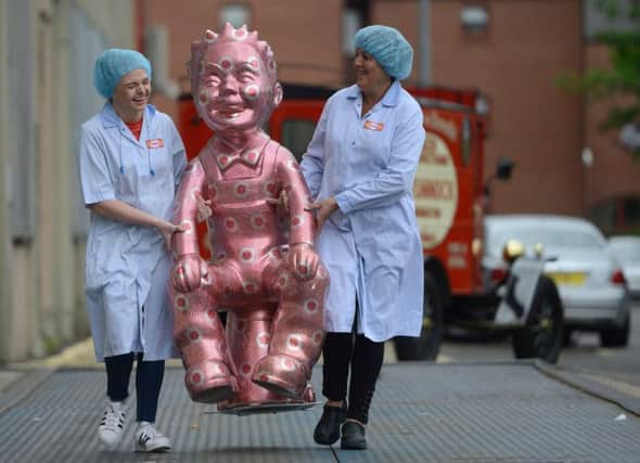 Factory workers Emma Brown, 19 and Michelle Quinn, 46,  admire a unique Oor Wullie sculpture. Picture: SWNS