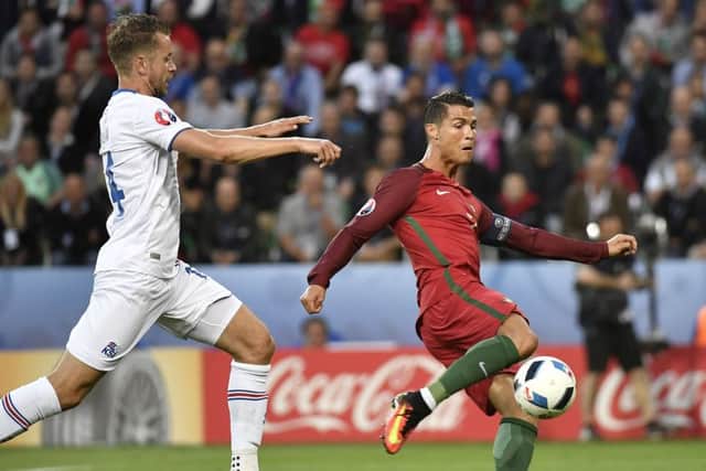 Kari Arnason (L) vies for the ball with Cristiano Ronaldo during last night's match. Picture: AFP/Getty