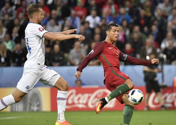 Kari Arnason (L) vies for the ball with Cristiano Ronaldo during last night's match. Picture: AFP/Getty