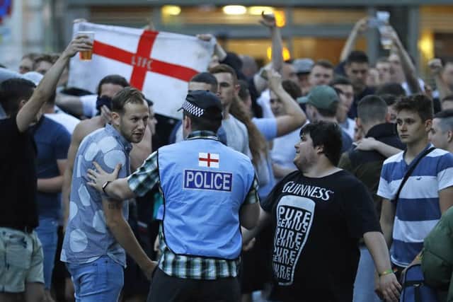An English police officer tries to calm England supporters in downtown Lille. Picture: Darko Vojinovic