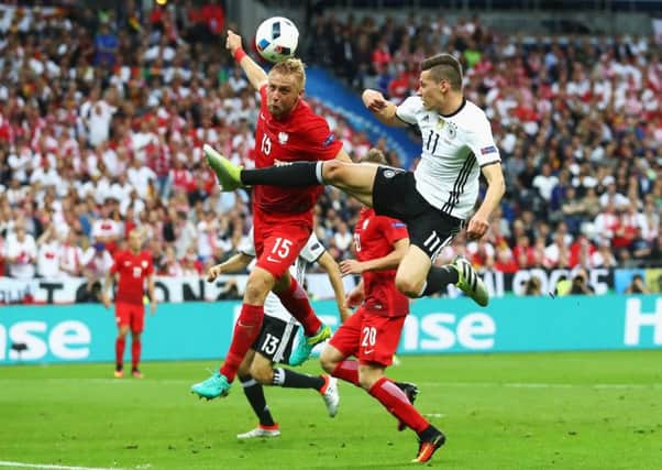 Kamil Glik of Poland and Julian Weigl of Germany clash during the Group C match at the Stade de France. Picture: Alexander Hassenstein/Getty Images