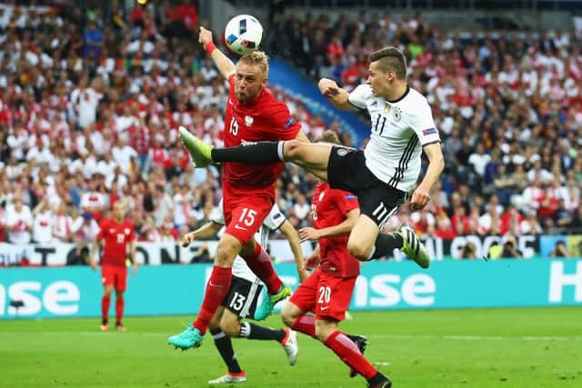 Kamil Glik of Poland and Julian Weigl of Germany clash during the Group C match at the Stade de France. Picture: Alexander Hassenstein/Getty Images