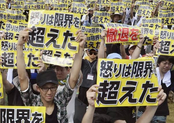 Many people held signs demanding the US Marines leave and military numbers be scaled back. Picture: AP
