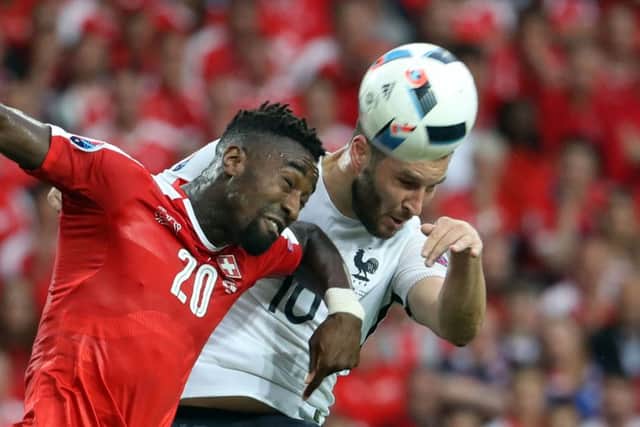 Switzerlands Johan Djourou and Andre-Pierre Gignac of France come together in an aerial challenge at the Stade Pierre-Mauroy last night. Picture: AFP/Getty Images