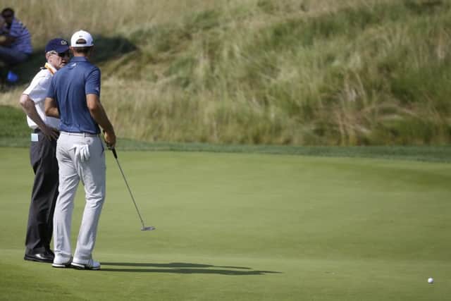 Dustin Johnson, right, talks to a rules official on the fifth green during the final round of the US Open. Picture: AP