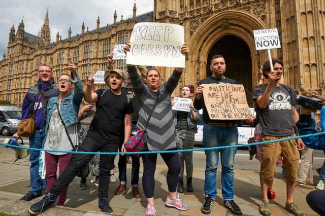 Demonstrators hold up placards as they protest outside the British Parliament in central London. Picture: AFP/Getty
