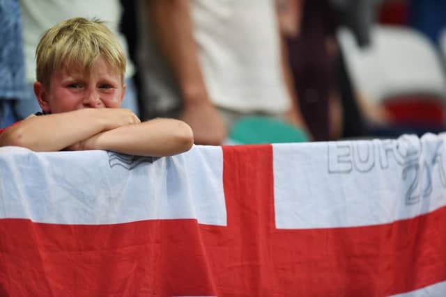 A young England fan looks on distraught after England's loss to Iceland at Euro 2016. Picture: AFP/Getty