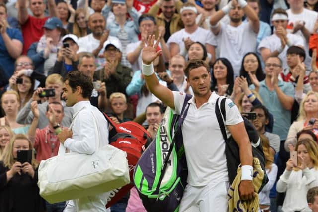 Marcus Willis waves as he leaves the court with Roger Federer.