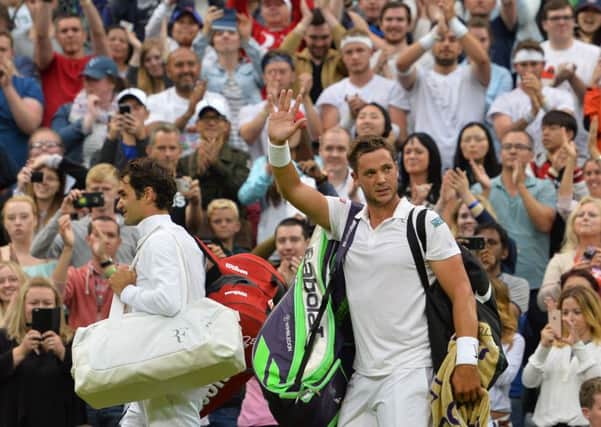 Marcus Willis waves as he leaves the court with Roger Federer.