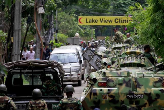 Bangladesh security personnel stand on top of armoured vehicles near the cafe. Picture: AP