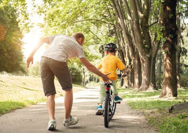 Father teaches his  son to ride a bicycle