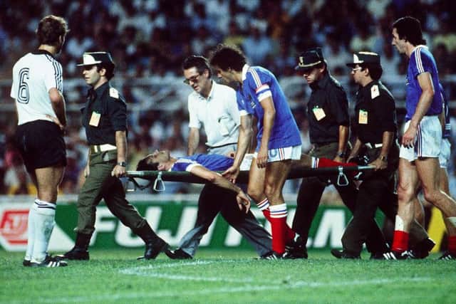 Michel Platini comforts France defender Patrick Battiston following a vicious collision with German goalkeeper Harald Schumacher during the 1982 World Cup semi-final in Seville. Picture: AFP/Getty Images