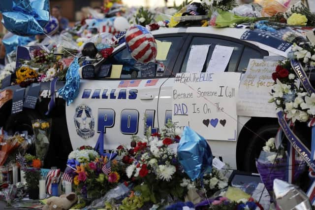 Notes, flowers and other items decorate a squad car at a make-shift memorial in front of the Dallas police department.(AP Photo/Eric Gay)