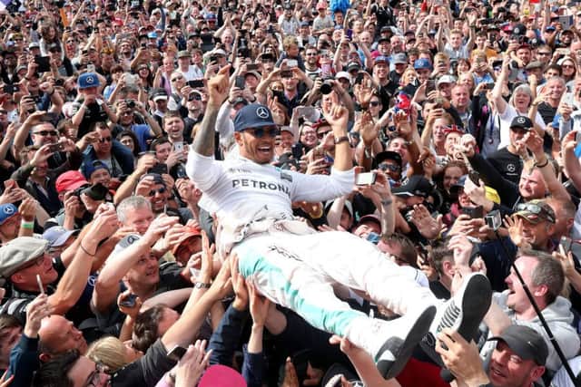 Lewis Hamilton crowd-surfs at Silverstone after his third consecutive win in the British Grand Prix. Picture: PA