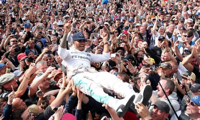 Lewis Hamilton crowd-surfs at Silverstone after his third consecutive win in the British Grand Prix. Picture: PA