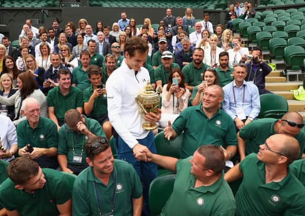 Andy Murray meets some of the All England Clubs ground staff during a return to Wimbledons Centre Court yesterday .Picture: Julian Finney/Getty