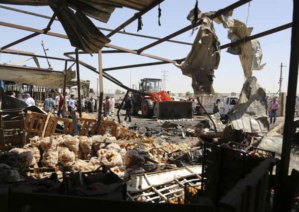 A bulldozer clears the rubble caused when a suicide bomber targeted a Baghdad market. Picture: AP Photo/Karim Kadim