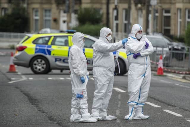 Forensic officers examine the scene of the attack in the Govan area of Glasgow when two men suffered gunshot wounds. Picture: John Devlin