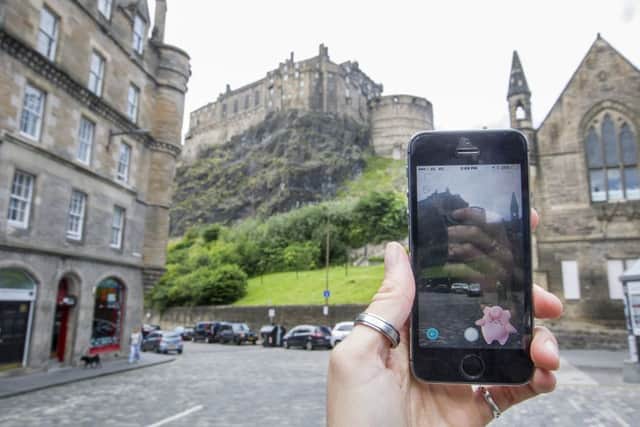 Pokemon Go game in Edinburgh's Grassmarket looking up to Edinburgh Castle.  Picture: SWNS