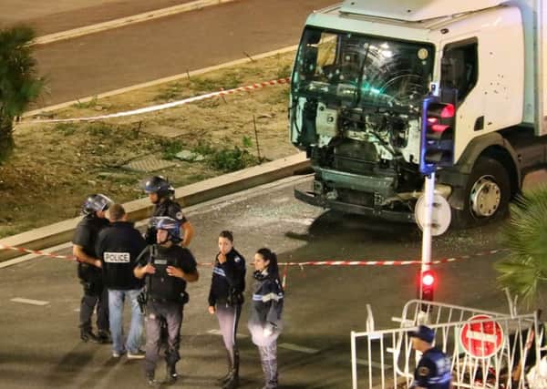 The lorry, riddled with bullet holes, on the Promenade des Anglais, with police on the scene. Picture: AP