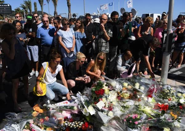 People visit the scene and lay tributes to the victims of a suspected terror attack on the Promenade des Anglais in Nice, France. Picture: Getty