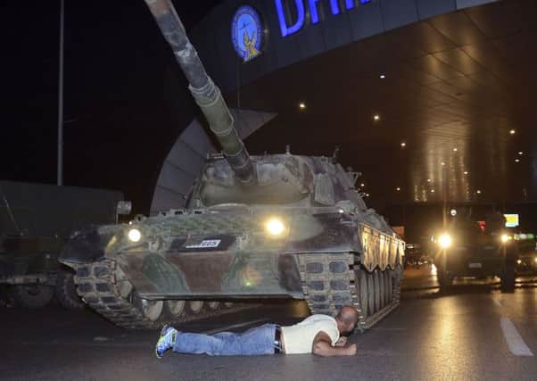 A man lies in front of a tank at Ataturk Airport. Picture: Ismail Coskun/IHA via AP