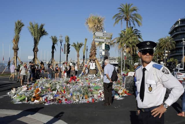 Police were on duty along the Promenade des Anglais in Nice yesterday as locals and tourists paid their respects. Picture: AP