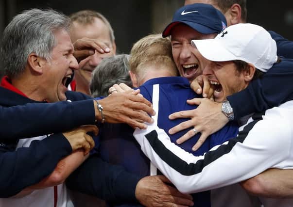 Kyle Edmund in the centre of the group hug alongside Andy Murray, right, as Britains Davis Cup team emerge victorious from their tie with Serbia in Belgrade. Picture: Getty