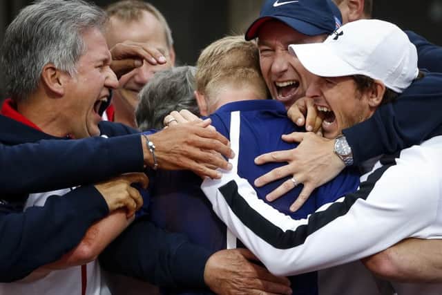 Kyle Edmund in the centre of the group hug alongside Andy Murray, right, as Britains Davis Cup team emerge victorious from their tie with Serbia in Belgrade. Picture: Getty