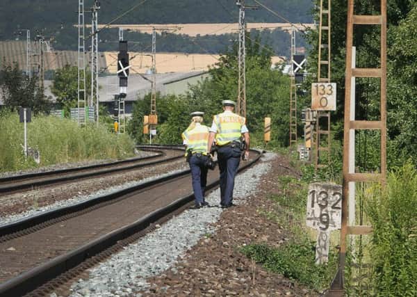 Police officers walk along train tracks in Wuerzburg, southern Germany, after a man attacked train passengers with an axe. Picture: Daniel Roland/AFP/Getty Images