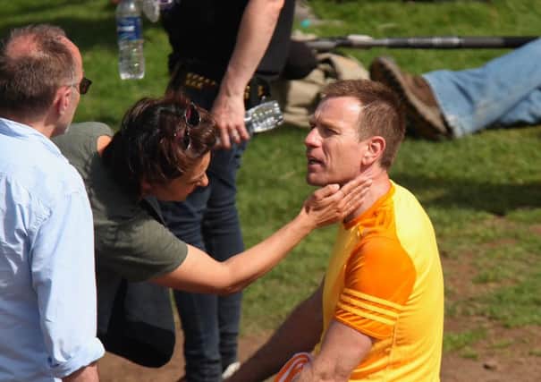 In a moment while filming was paused, a member of the film crew carefully dabbed the red-headed actor who plays the lead character Mark Renton with sun cream. Picture: Hemedia
