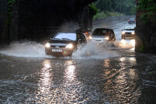 Cars struggle through flooding on a road in Port Dundas, Glasgow. Picture: Hemedia