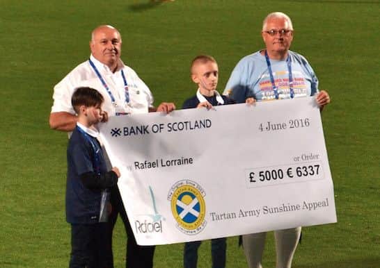 John Daly, chairman of the Tartan Army Sunshine Appeal, presents a cheque for Â£5,000 to French charity Rafael Lorraine before Scotland's friendly match against Franch in Metz. Picture: Contributed