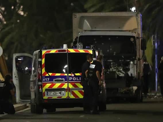 Police officers stand near the truck used in the Bastille Day terror attack in Nice