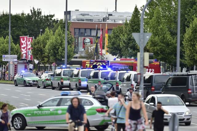 Police cars stand outside the Olympia shopping centre after the shooting. Picture: AP