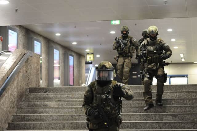 Heavily armed police forces walk through the underground station Karlsplatz. Picture: AP