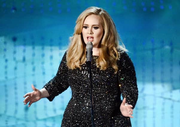 Adele stuns fan on stage with a kiss on the lips. Picture: Kevin Winter/Getty Images