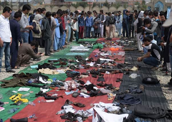 Relatives and friends inspect shoes and other belongings of those who were killed in a twin suicide attackin Kabul. Picture: AFP/Getty Images
