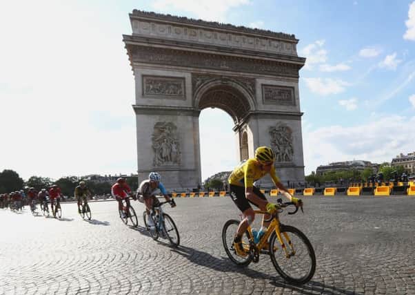 Chris Froome cycles past the Arc de Triomphe, left, and raises the trophy following his victory. Picture: Getty Images