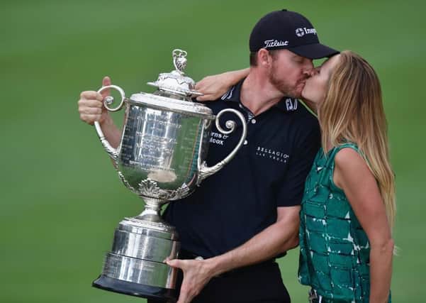 Jimmy Walker kisses his wife Erin while holding the Wanamaker Trophy. Picture: Getty Images