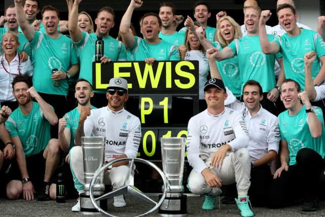 Britains Lewis Hamilton, left, and his German team-mate Nico Rosberg celebrate with the Mercedes GP staff at Hockenheim. Picture: Getty