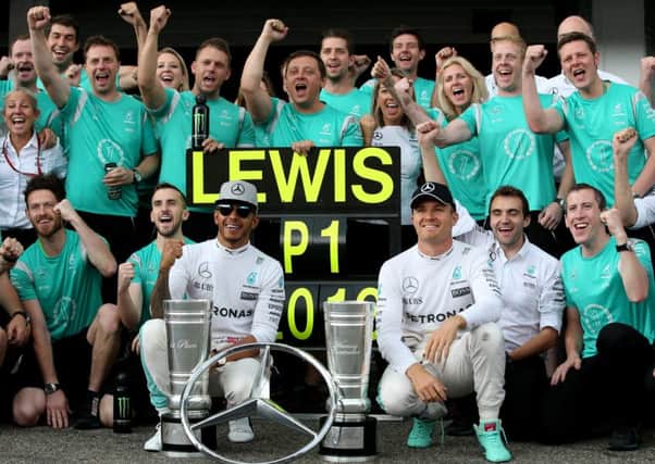 Britains Lewis Hamilton, left, and his German team-mate Nico Rosberg celebrate with the Mercedes GP staff at Hockenheim. Picture: Getty
