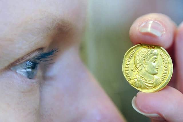 Auction expert Claire Godwyn examines a Roman Empire gold coin from A.D. 364-375 in Glasgow. Picture: John Devlin