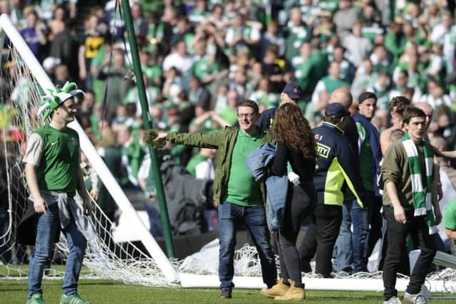 Hibs fans celebrate winning the Scottish Cup on the Hampden pitch. Picture: Neil Hanna