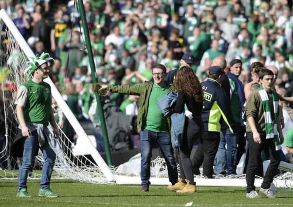 Hibs fans celebrate winning the Scottish Cup on the Hampden pitch. Picture: Neil Hanna